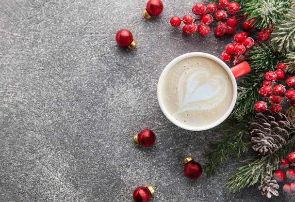 Kopje latte koffie en kerstversiering op een donkere betonnen achtergrond. Kerstmis en nieuwjaarsviering concept. Bovenaanzicht met kopieerruimte, vlakke lay. - Foto, afbeelding