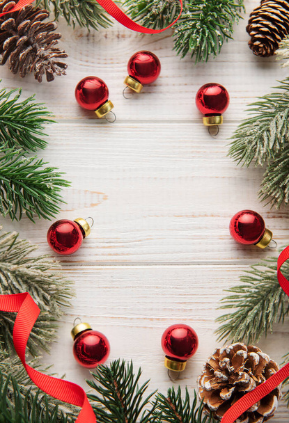 Decoración navideña con cinta roja haciendo un marco sobre un fondo de madera blanca. Temas navideños. Colocación plana, espacio de copia - Foto, imagen