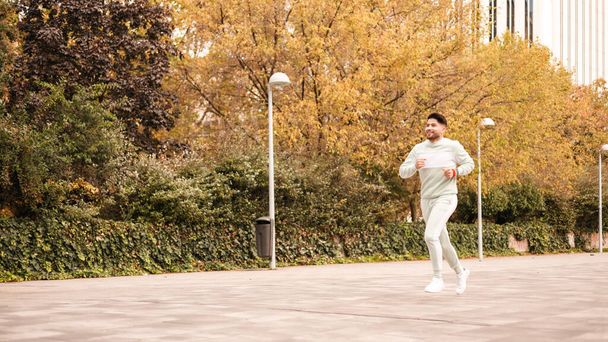 молодой гей-атлет, бегущий на открытом воздухе с lgbt аксессуарами - Фото, изображение