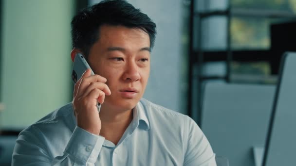 Triste asiatique cadre dirigeant homme d'affaires gestionnaire coréen d'âge moyen japonais chinois réponse mobile appel travail dans le bureau parler téléphone résoudre problème d'affaires conversation à distance par connexion cellulaire 5g - Séquence, vidéo