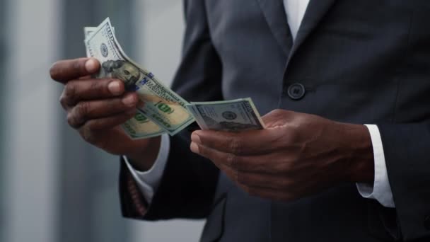 Great financial profit. Close up shot of unrecognizable black businessman in suit counting money, calculating his income, standing outdoors, slow motion, empty space - Footage, Video