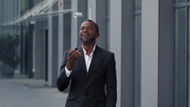 Successful occupation. Outdoors portrait of happy middle aged african american businessman enjoying great profit, playing with bunch of money and smiling, slow motion, free space - Footage, Video