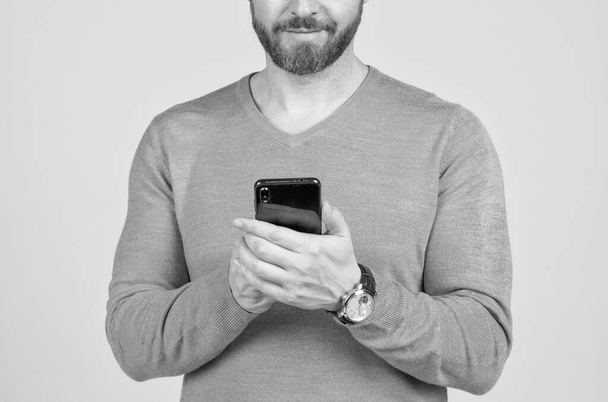 przycięty mężczyzna z brodą czatujący online na smartfonie, komunikacja. - Zdjęcie, obraz