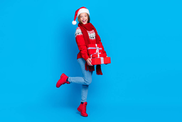 Full length photo of funny impressed school girl dressed red x-mas ornament pullover holding gifts pile stack isolated blue color background. - Foto, Imagem