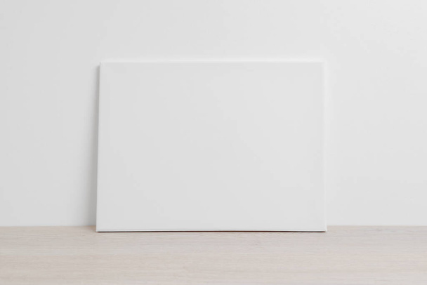 Мистецьке полотно в горизонтальному положенні на підлозі, спираючись на білу стіну. Чиста тканина для презентації макетного мистецтва
 - Фото, зображення