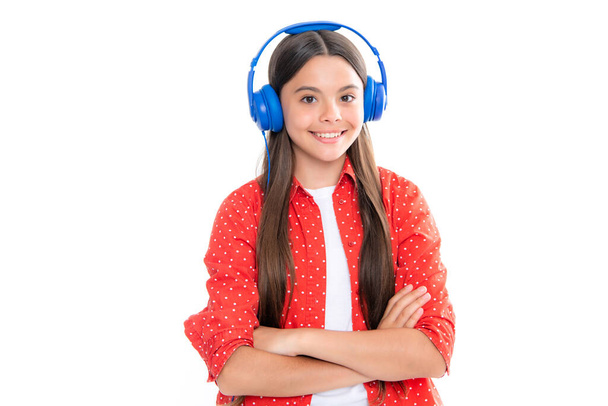 Παιδική μουσική ακούγοντας με ακουστικά. Κορίτσι που ακούει τραγούδια μέσω ασύρματων ακουστικών. Εξαρτήματα συσκευής ακουστικών. Έφηβο κορίτσι που ακούει μουσική. Θετικά και χαμογελαστά συναισθήματα - Φωτογραφία, εικόνα