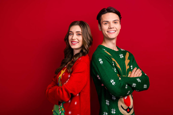 Photo of confident cheerful brother sister wear xmas sweaters arms folded empty space isolated red color background. - Fotografie, Obrázek
