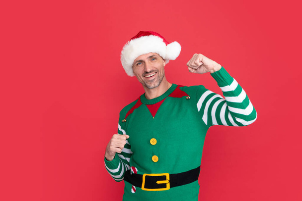 happy man in elf costume. xmas guy in santa claus hat on red background. happy new year. merry christmas. happiness and success. - Photo, Image