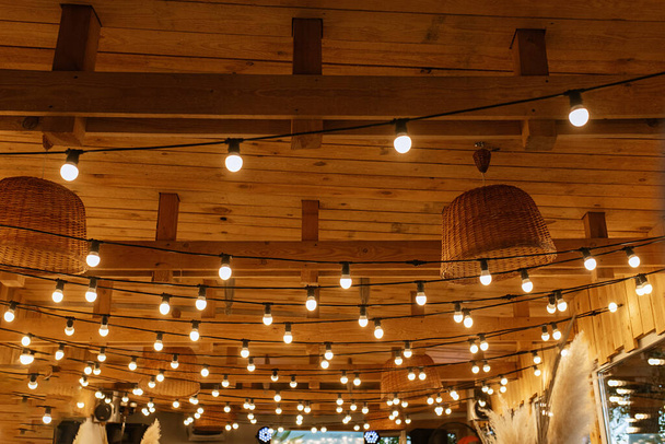 атмосферні теплі лампочки, загорнуті в гірлянди, щоб прикрасити свято
 - Фото, зображення