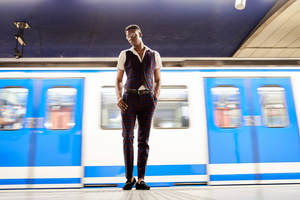Longue exposition de l'homme seul à la station de métro avec train flou - Photo, image