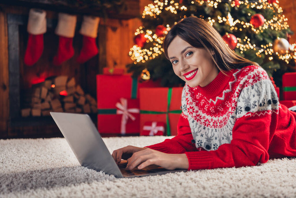 Photo of cheerful attractive lady lying fluffy carpet use gadget netbook enjoy winter magic cozy evening house indoors near fireplace. - Фото, зображення