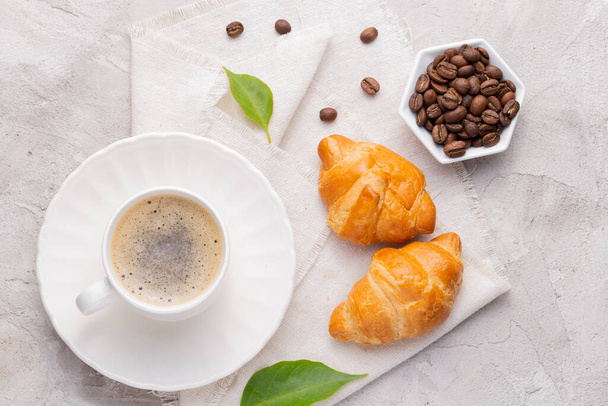 Copo de café, grãos de café torrados e pão na mesa branca - Foto, Imagem