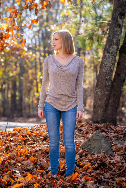 Ein hinreißendes blondes Model genießt das Outdoor-Herbstwetter - Foto, Bild