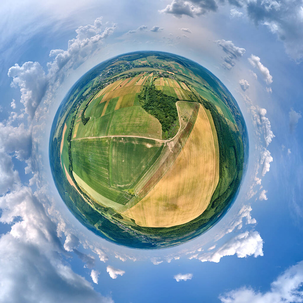 Vista aérea desde gran altitud del pequeño planeta tierra con campos agrícolas verdes y amarillos cultivados con cultivos en crecimiento en el brillante día de verano. - Foto, imagen