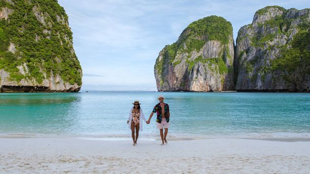 Maya Körfezi plajında yürüyen bir çift kadın ve erkek sabahleyin turkuaz renkli okyanusla Koh Phi Phi Tayland 'da.  - Fotoğraf, Görsel