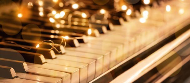 Klavírní klávesy se zářivými vánoční světly, detailní záběr - Fotografie, Obrázek