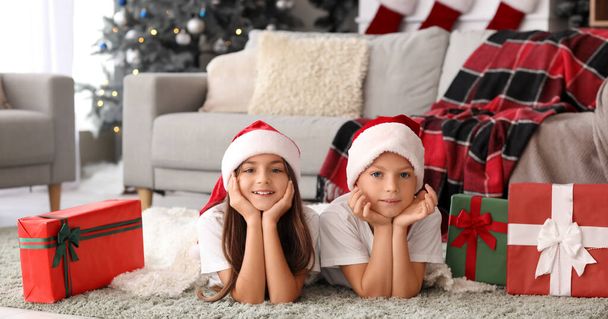 Cute children in pajamas and Santa hats at home - Photo, Image