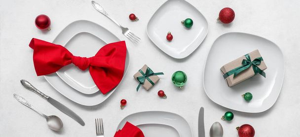 Mooie tafel setting met kerstballen en geschenken op witte achtergrond - Foto, afbeelding