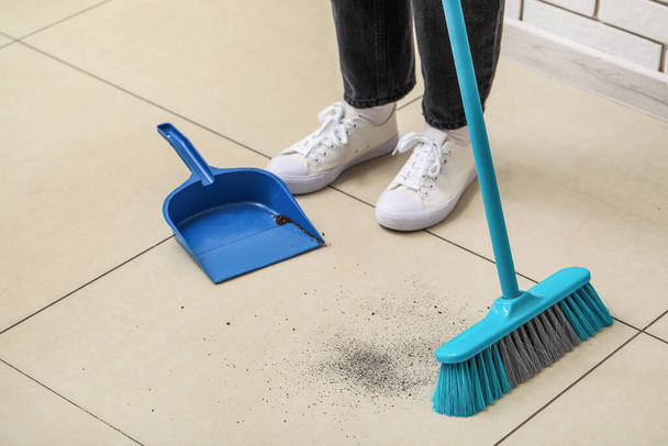 Donna spazzare pavimento piastrellato leggero con scopa e paletta - Foto, immagini