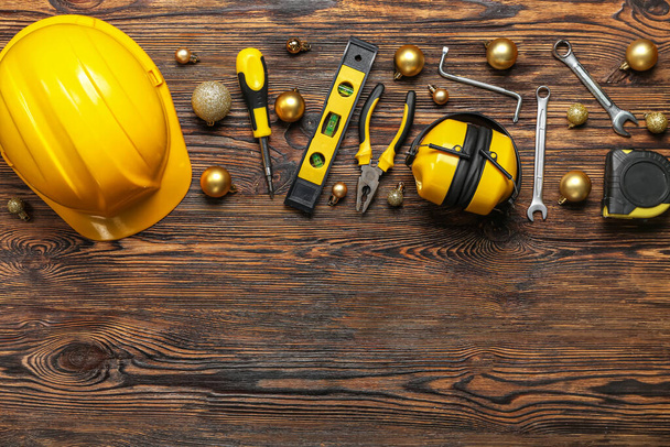 Builder's tools with Christmas balls on wooden background - Photo, Image