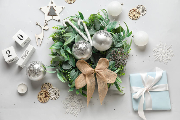 Kompozíció stílusos karácsonyi koszorú, ajándék és dekoráció fehér háttér - Fotó, kép