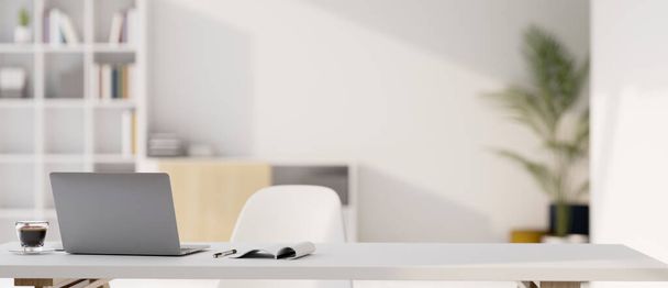 Moderni minimaalinen valkoinen toimistotila, valkoinen työtila kannettavalla kannettavalla tietokoneella, kahvikupilla, kirjalla ja kopiotilalla hämärtyneen valkoisen toimistotaustan päällä. 3d renderöinti, 3d kuva - Valokuva, kuva