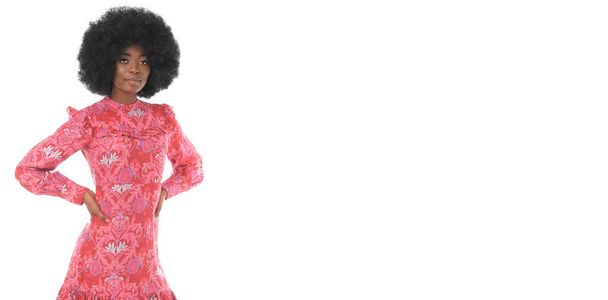 Hezká brunetka model s afro vlasy v červené květinové šaty na izolovaném bílém pozadí s místem pro text. - Fotografie, Obrázek