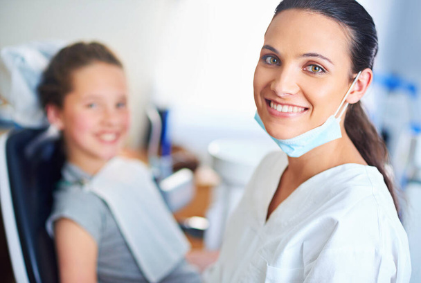 Dwa idealne uśmiechy. Portret kobiety dentysty i dziecka w gabinecie dentystycznym - Zdjęcie, obraz