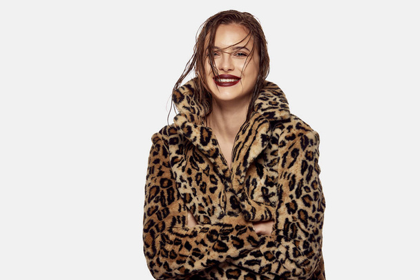 Portrait of young beautiful girl posing in stylish animal print coat and smiling isolated over white background. Concept of beauty, skin care, cosmetology, plastic surgery, makeup, fashion - Photo, image