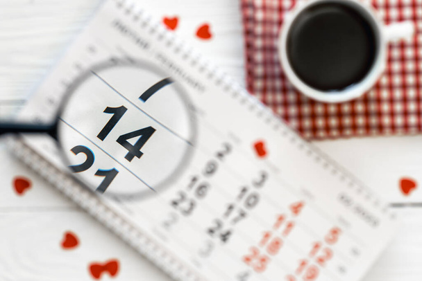 Composition for Valentines Day with a calendar, a cup of tea on a white wooden background, flat lay. - Foto, Bild