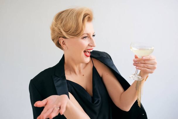 Смеющиеся белые зрелые стильные элегантные женщины в смокинге с бокалом игристого вина. Вечеринка, праздник, антивозрастная концепция  - Фото, изображение
