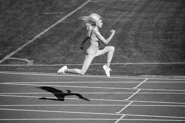 sport woman in sportswear sprinting on stadium running track before training fitness, active lifestyle. - Photo, Image