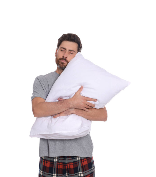 Sleepy handsome man hugging soft pillow on white background - 写真・画像
