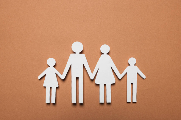 Paper family figures on brown background, top view. Insurance concept - Foto, immagini