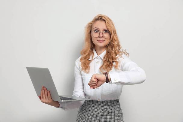 Emotional businesswoman with laptop in turmoil over being late on white background - Photo, Image