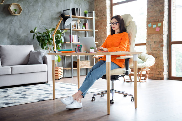 Photo of positive confident lady dressed orange pullover answers mails modern gadget indoors workshop workplace workstation. - 写真・画像