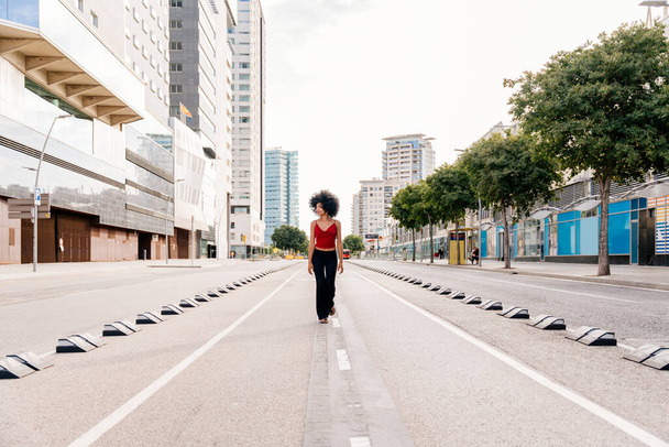 Linda jovem mulher africana feliz com penteado encaracolado afro passeando na cidade - Estudante negro alegre andando nas ruas - Foto, Imagem