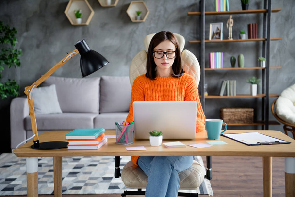 Photo of busy confident lady dressed orange pullover answers mails modern gadget indoors workshop workplace workstation. - Фото, зображення