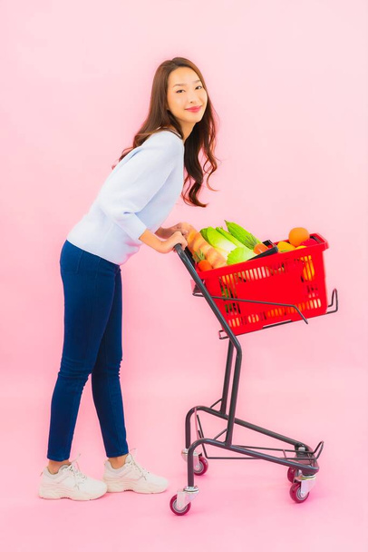 Retrato bela jovem mulher asiática com fruta vegetal e mercearia em cesta em rosa isolado fundo - Foto, Imagem