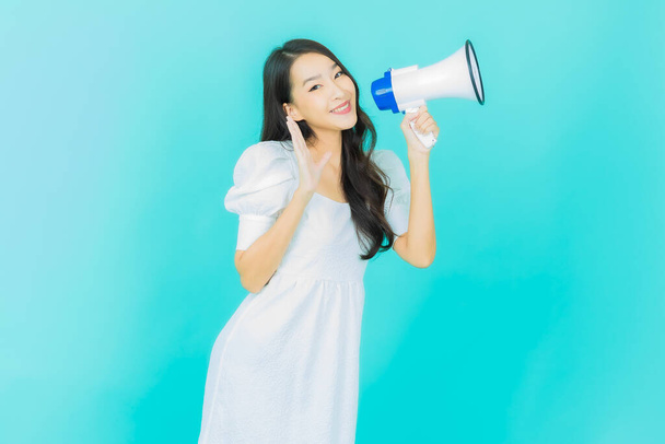 Portrait beautiful young asian woman smile with megaphone on color background - Valokuva, kuva