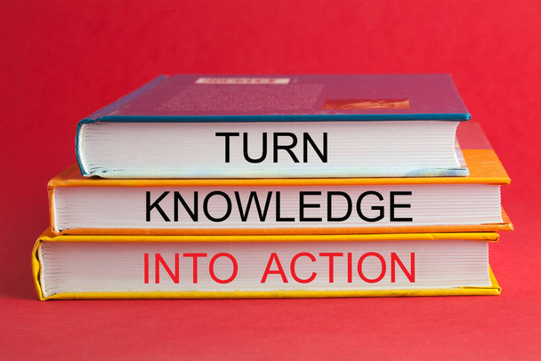 Livres avec phrase Transformer la connaissance en action sur fond rouge. Concept de motivation - Photo, image