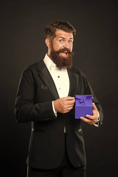 amazed happy man in tuxedo bow tie formalwear on black background with box. shopping sale. - Zdjęcie, obraz