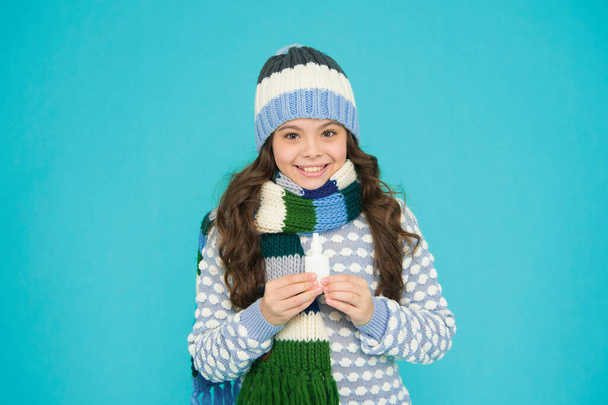 free your stuffy nose. happy teen girl in knitwear hold nasal spray. kid winter fashion style. child care of health. coronavirus pandemic quarantine. healthy childhood. treat runny nose with drops. - Photo, Image
