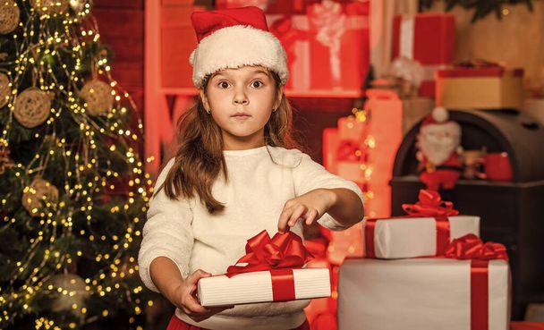 Magic time. Xmas gift shopping. Family tradition. Gift package. Merry Christmas and happy holidays. Winter holidays. Little girl hold gift box. Kid hold present box decorated interior background. - 写真・画像