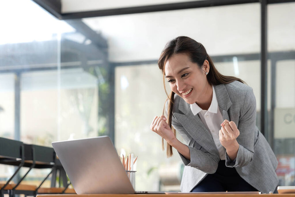 Opgewonden gelukkig aziatische vrouw kijken naar de telefoon scherm, vieren van een online overwinning, overgelukkig jonge aziatische vrouw schreeuwen van vreugde, geïsoleerd over een witte wazig achtergrond. - Foto, afbeelding