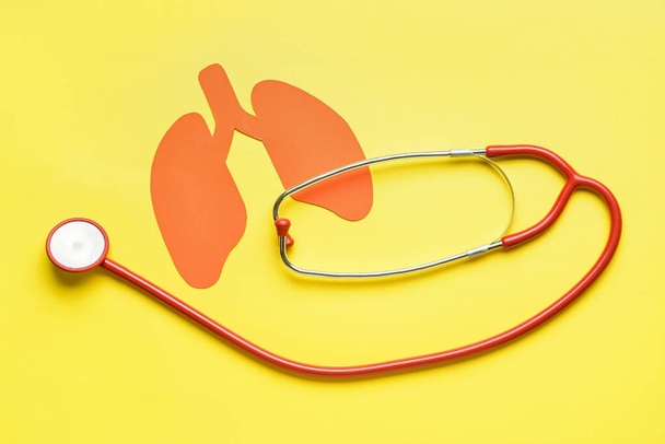 Red paper lungs with stethoscope on yellow background - 写真・画像