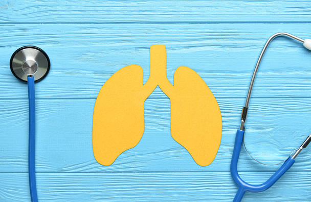 青い木製の背景に聴診器付き黄色の紙肺 - 写真・画像