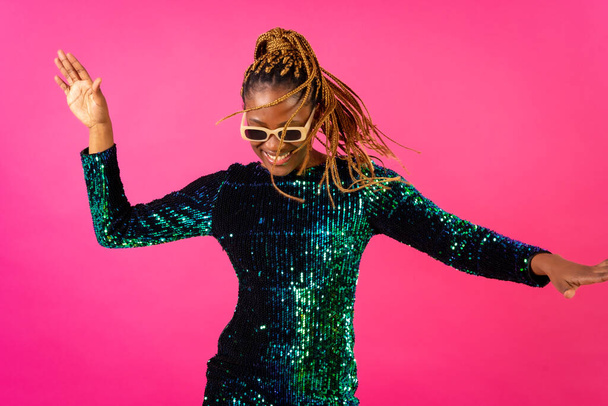 Black ethnic woman with braids party dancing on pink background, having fun ballerina - Foto, afbeelding