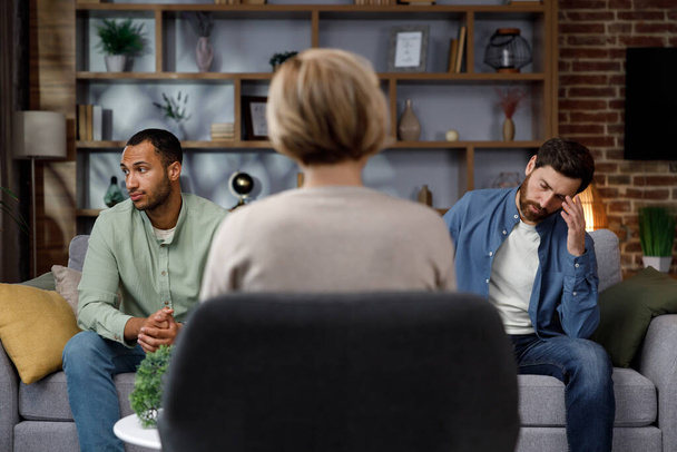 Family quarrel at the reception at the psychologist. LGBT couple at a psychotherapists appointment. Psychologist for gays. Support for the LGBT community in visiting a psychologist - Foto, Imagem