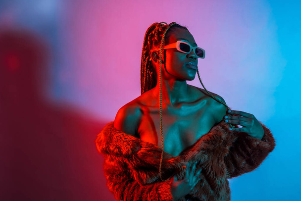 Attractive black ethnic woman with braids with red and blue led lights, trap dancer - 写真・画像